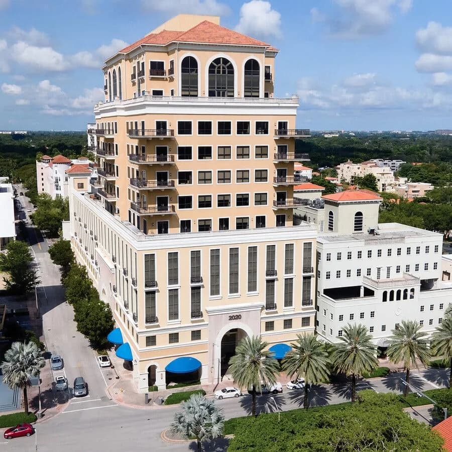 Aerial view of a multistory building with a parking structure at its base