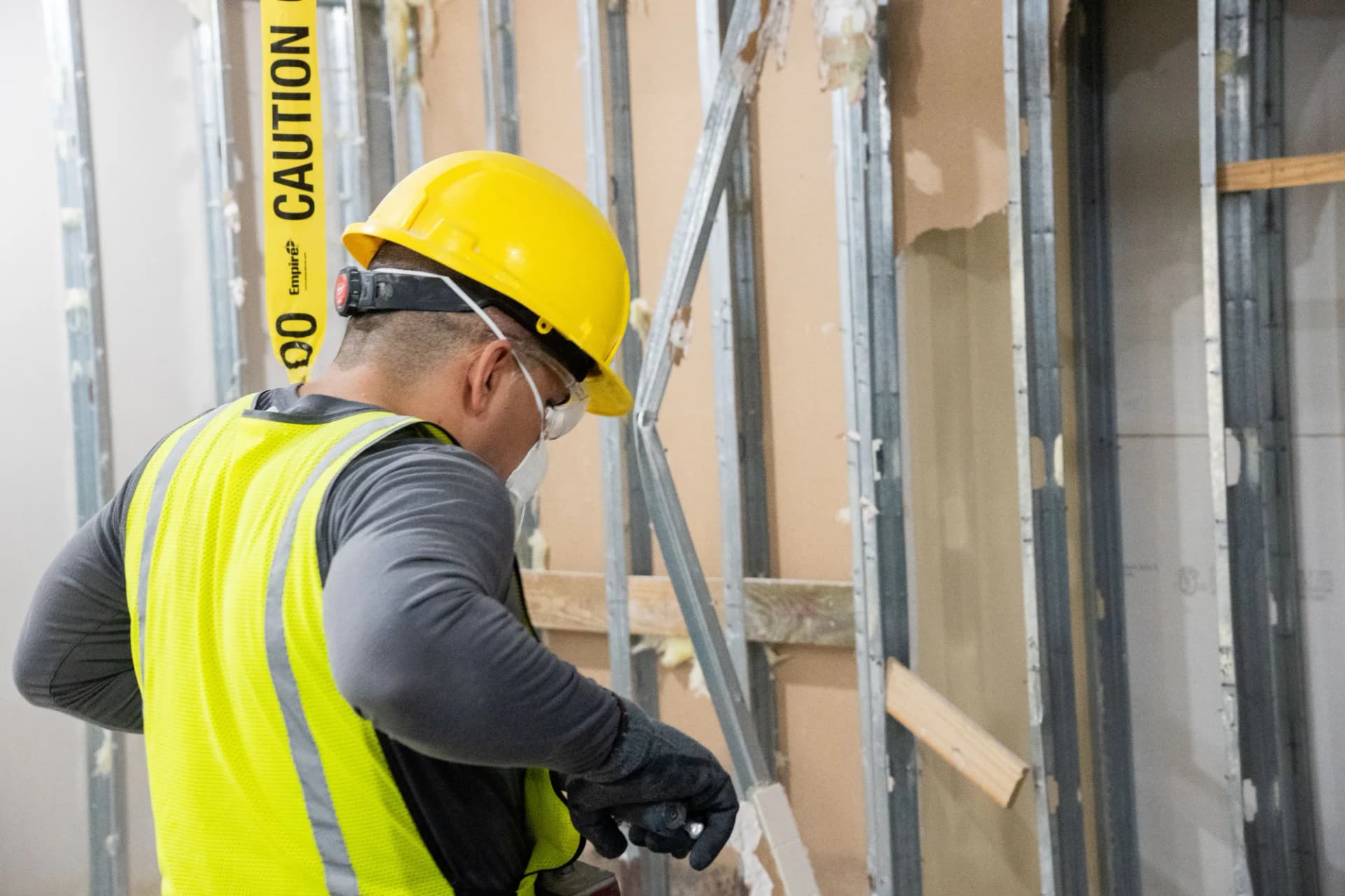 JZ crew member wearing a hard hat, eye protection and gloves during interior work at MOB Pompano